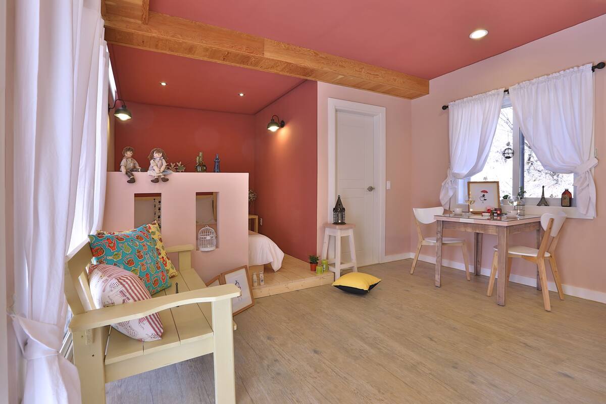 Une pièce confortable avec un lit, une petite table et une fenêtre avec des rideaux.