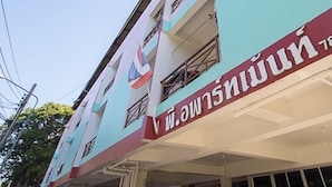 A multi-story building with a prominent red and white sign on the ground floor. - P Apartment Nonthaburi (Nonthaburi)