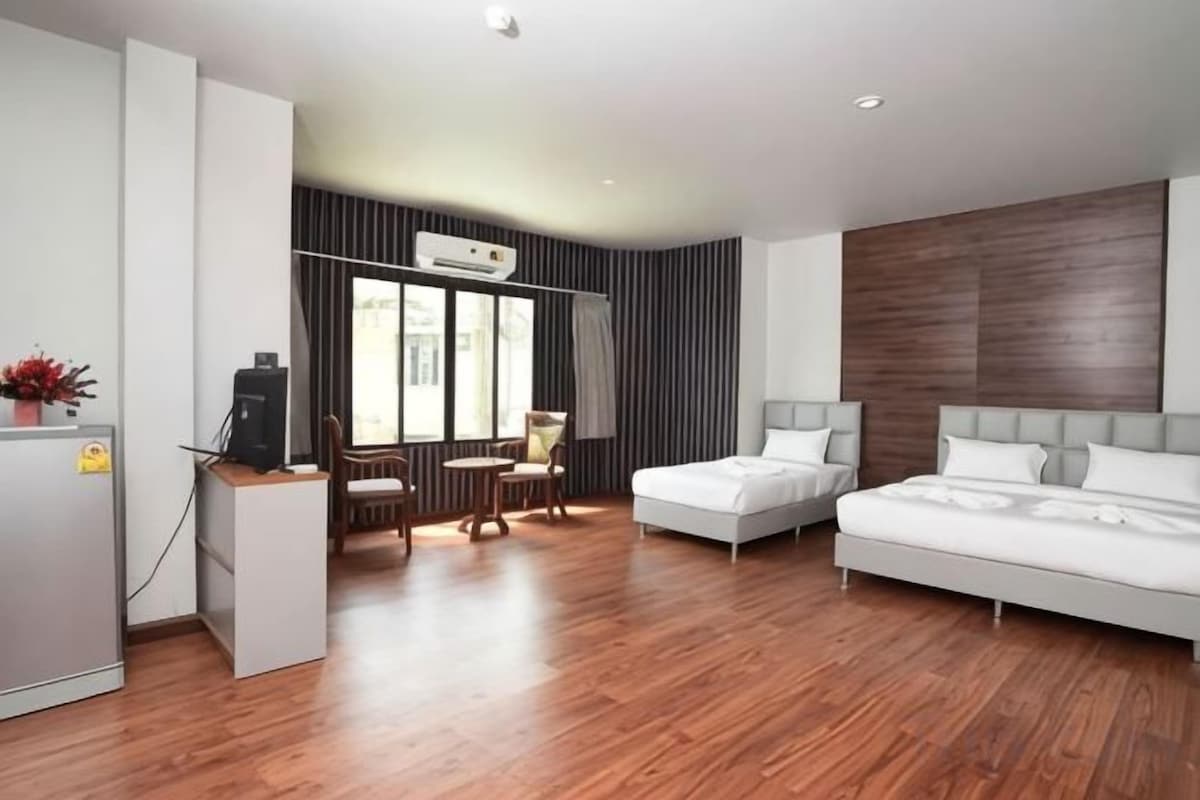 A modern hotel room with a bed, a desk, and a chair.