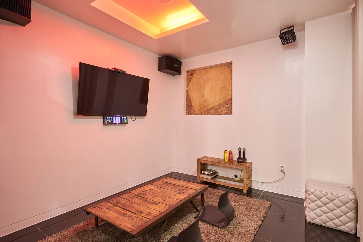 A modern living room with a flat-screen TV, a wooden coffee table, and a small side table with decorative items.