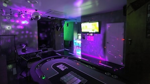 Una habitación con cabina de DJ, televisión y una bola de discoteca.