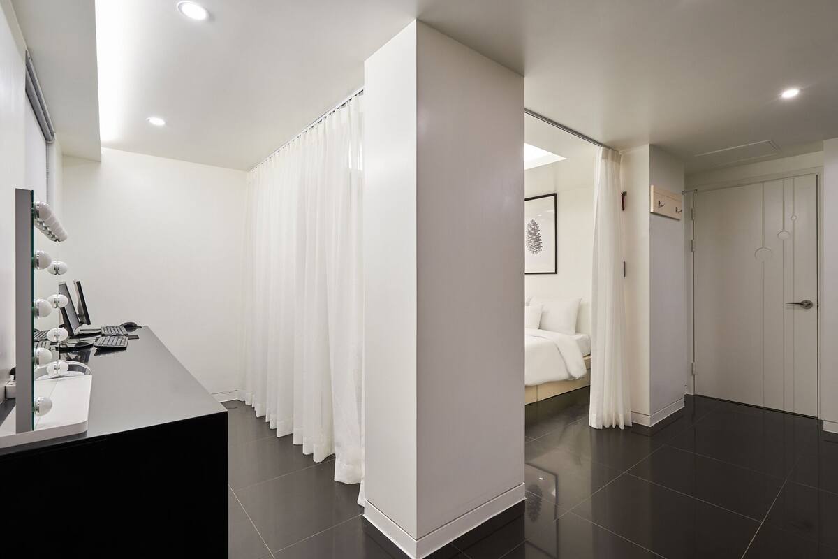 A modern bathroom with a vanity, a shower curtain, and a toilet.
