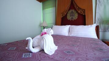 A hotel room with a bed, a nightstand, a lamp, and a decorative headboard.