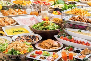 A buffet with various food items including fruits, vegetables, meats, and beverages.