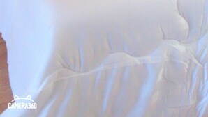 A bed with white bedding and two pillows with a floral design. - Charlee House (Trang)