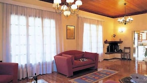 Una sala de estar con un sofá rojo, una chimenea y un candelabro.