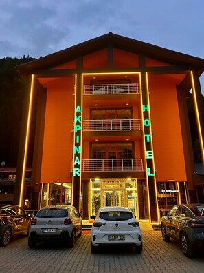 A hotel with a double-story structure, a reception area, and multiple cars parked in front. - Akpinar Hotel (Çaykara)