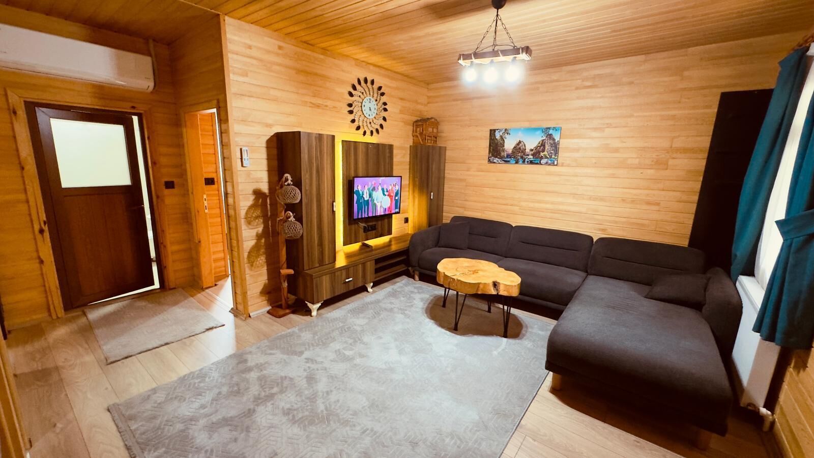 Un interior de madera con sofá, televisor y alfombra.