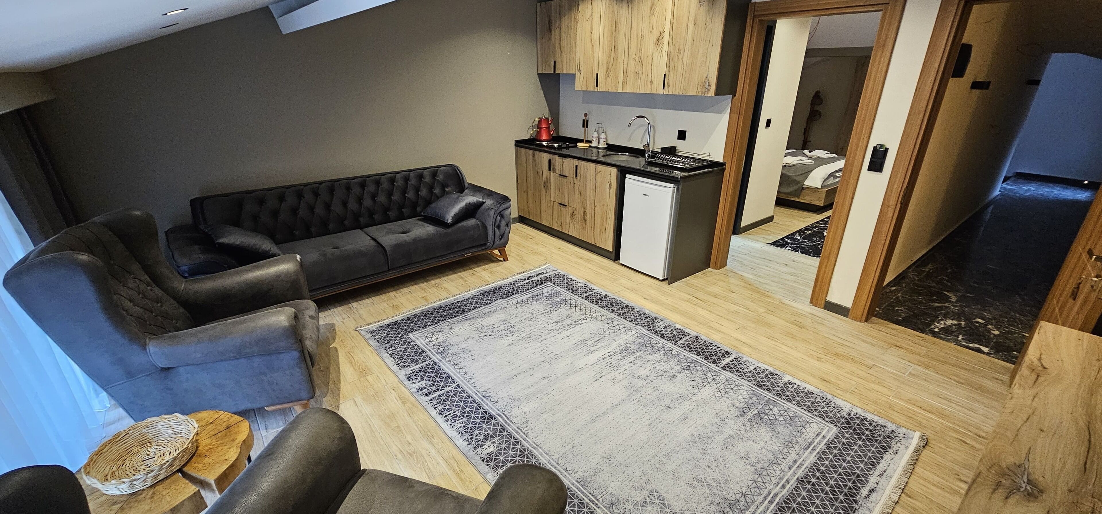 A compact living space with a sofa, a small kitchen area, and a dining table.
