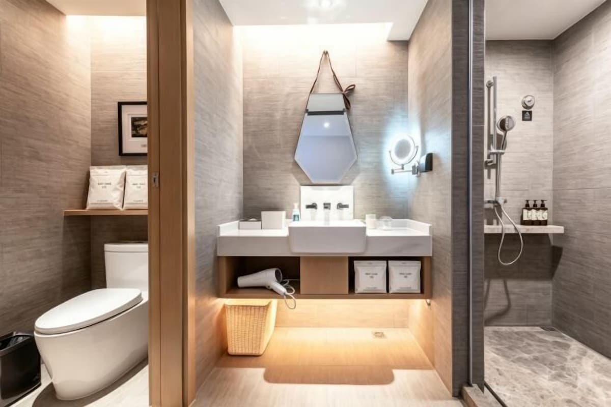 A modern bathroom with a toilet, bidet, and shower area.