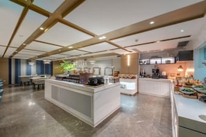 A modern kitchen with a central island, built-in appliances, and a seating area.