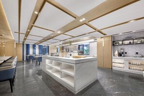 Una cocina moderna con una isla central, electrodomésticos integrados y una zona de estar con sillas.