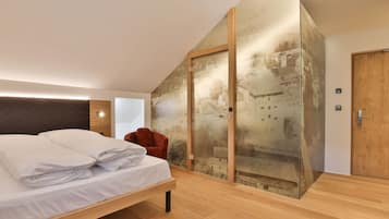 A modern bedroom with a bed, a red chair, and a large glass wall with a cityscape view.
