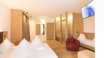 Une chambre d’hôtel avec un lit, une chaise rouge, un téléviseur et des murs en bois.