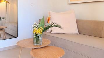 Departamento Deluxe, vista parcial al mar | Área de sala de estar | Televisión LED de 43 pulgadas con canales digitales
