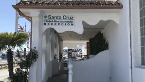 Un edificio con un cartel que dice "Santa Cruz Hotel-Restaurante RECEPCIÓN".