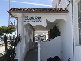 Un edificio con un cartel que dice "Santa Cruz Hotel-Restaurante RECEPCIÓN".