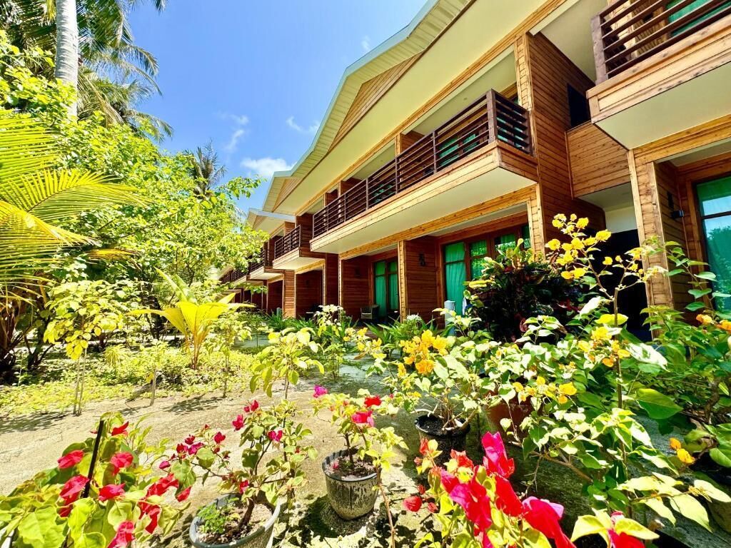 Un hôtel à la structure de deux étages, doté d’un jardin extérieur et de nombreux balcons.