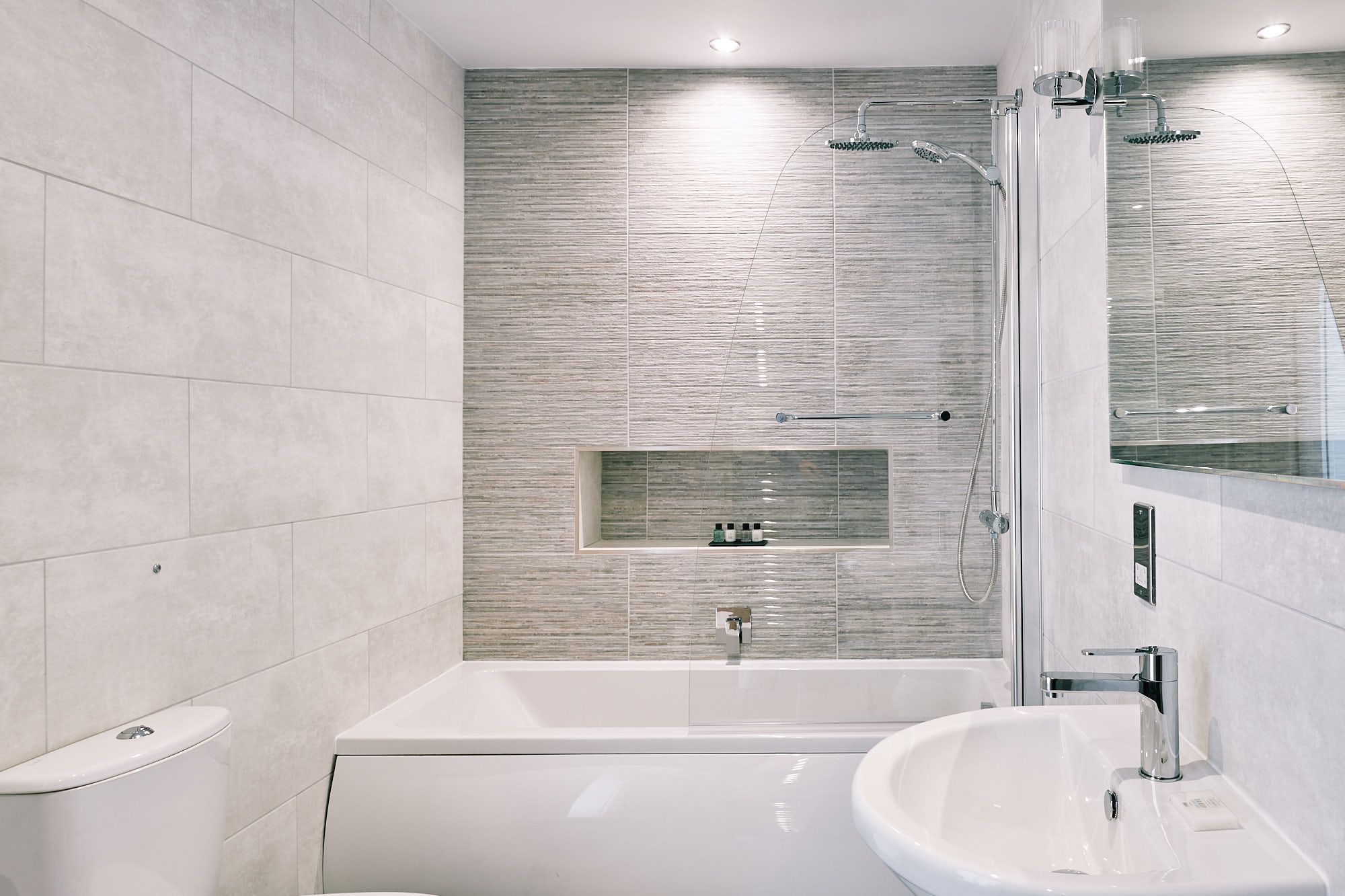 A modern bathroom with a bathtub, a shower, and a sink.