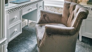 A room with a vanity, a television, a chair, and a window with curtains. - The Queens Hotel Lytham (Lytham St. Anne's)