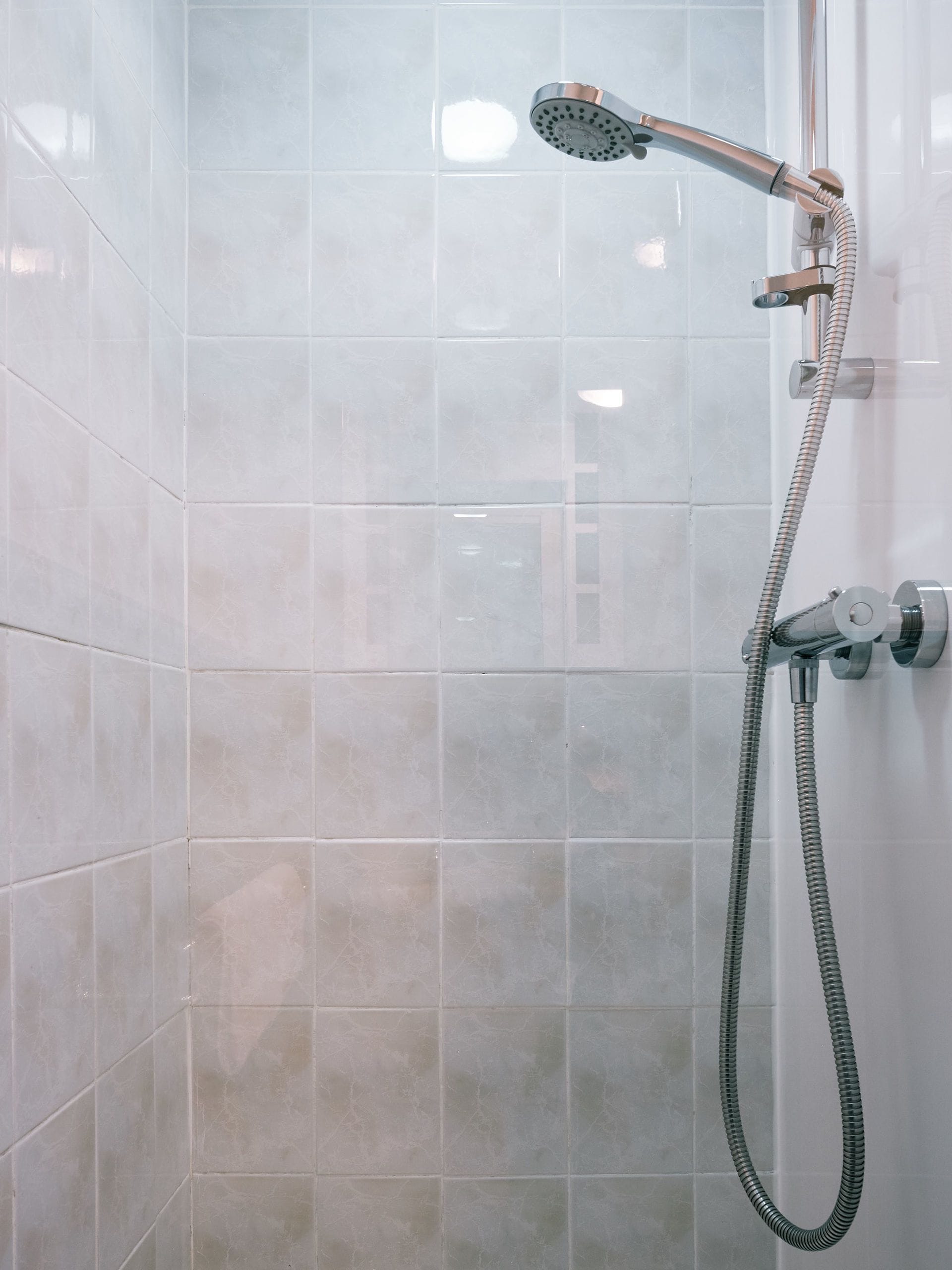 A shower with a handheld showerhead and a flexible hose.