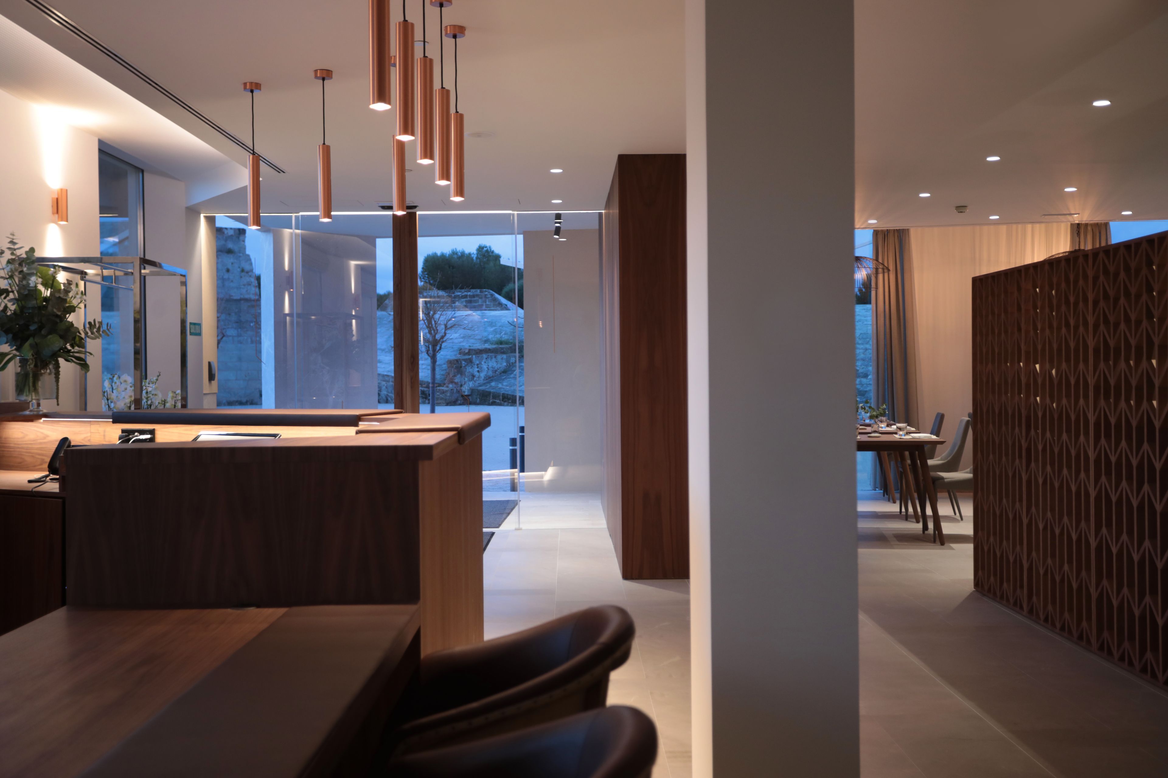 Un moderno vestíbulo de hotel con mostrador de recepción, zona de estar y vistas al exterior.