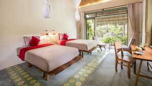 A room with two beds, a dining table, and a view of greenery outside. - Mekong Home (Phuoc Long)