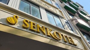 Un edificio de varios pisos con el nombre "SENKOTE" visible en la fachada.