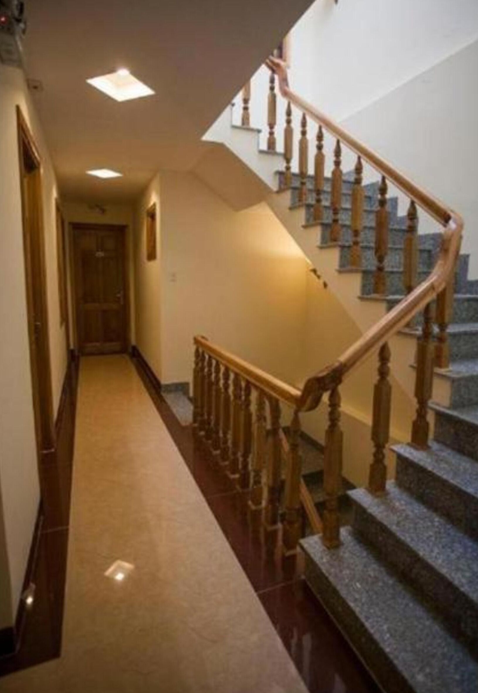 A hallway with a wooden staircase leading to a landing.