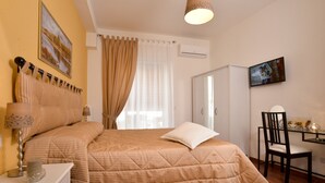 A bedroom with a bed, a nightstand, a chair, a wardrobe, and a television on the wall. - Beside the Vatican (Rome)