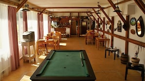 A cozy room with a pool table, wooden furniture, and a bar area. - Penzión Western (Ruzomberok)