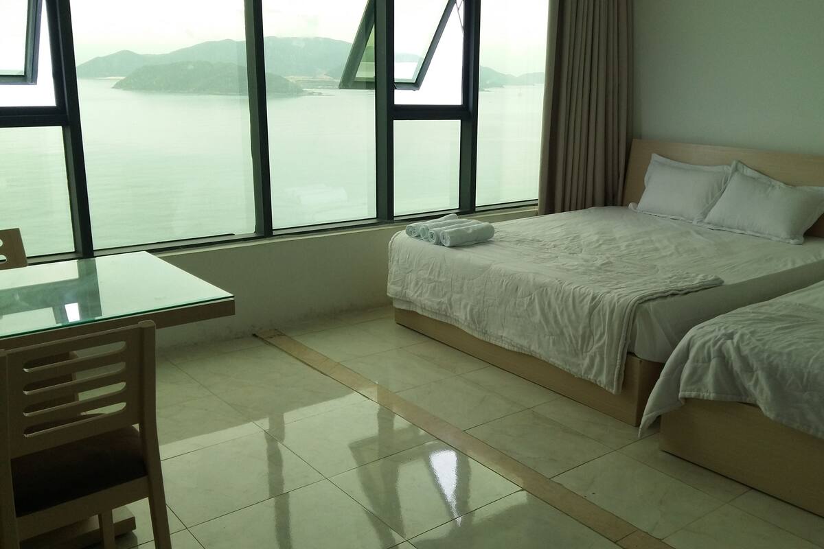 Habitació d'hotel amb llit, escriptori i vistes al mar.