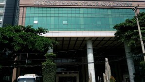 Een modern gebouw met een bord waarop staat: MUONG THANH NHA TRANG CENTRE.