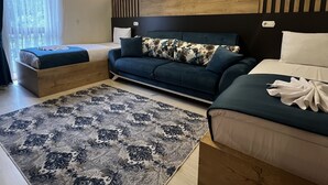 Un dormitorio moderno con una cama grande, un sofá y un pequeño rincón de descanso.