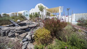 A white building with a curved roof and a yellow pergola. - Villa Agrikoia (Santorini)