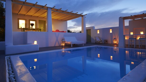 A modern pool area with a clear pool, lounge chairs, and a pergola structure. - Villa Agrikoia (Santorini)