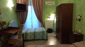 Ein Zimmer mit Bett, Schreibtisch, Kleiderschrank und Heizkörper.