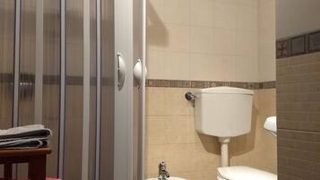 Ein Badezimmer mit Duschkabine, Bidet und Toilette.