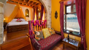 Una habitación con una cama, un sofá y un ventanal con cortinas.