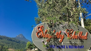 A sign for 'Stately Shunned Guest House & Restaurant' with a mountainous backdrop. - Slightly Chilled Yellow House (Nallathanniya)