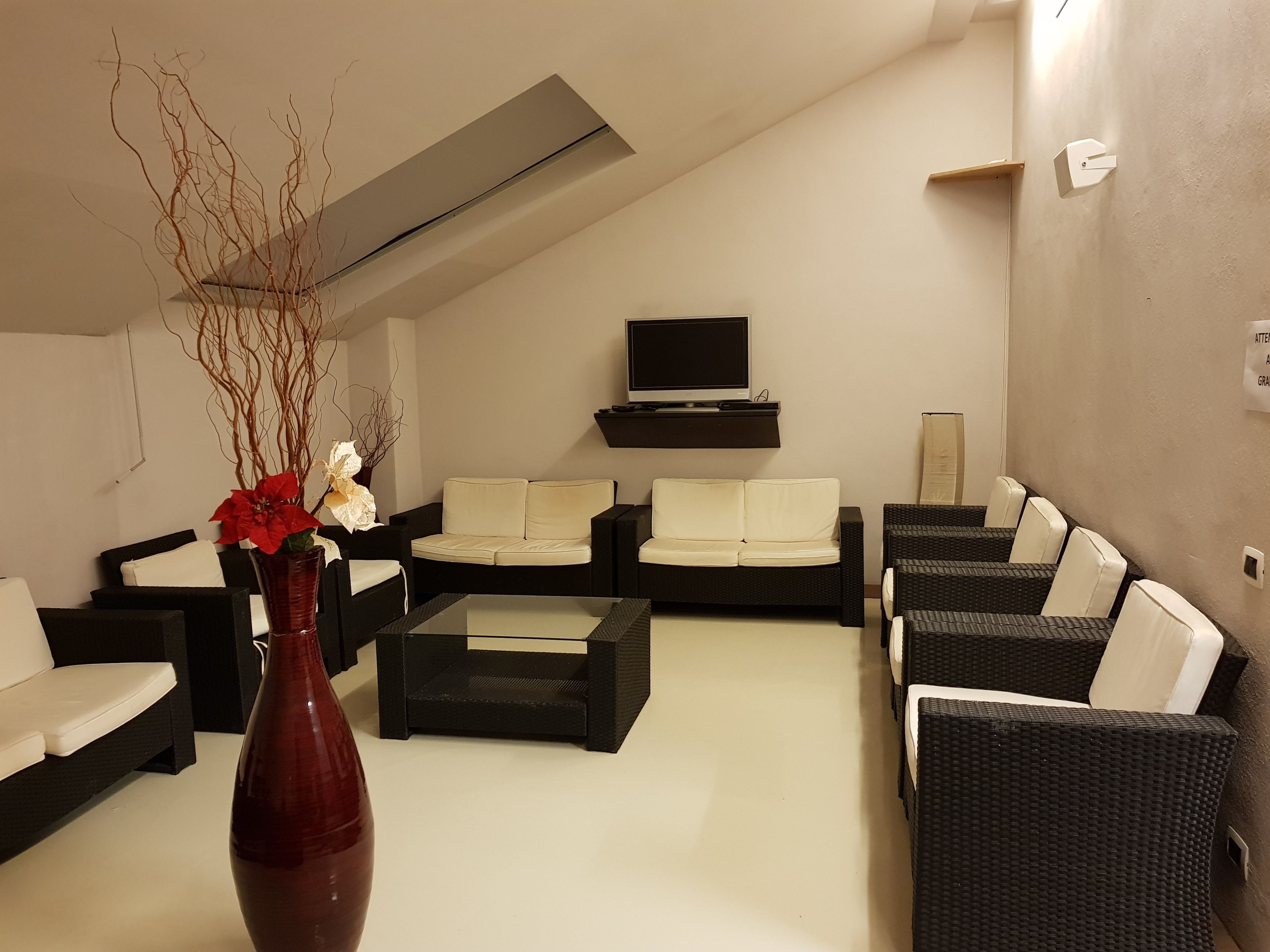 A modern living room with a sofa set, a coffee table, and a TV mounted on the wall.