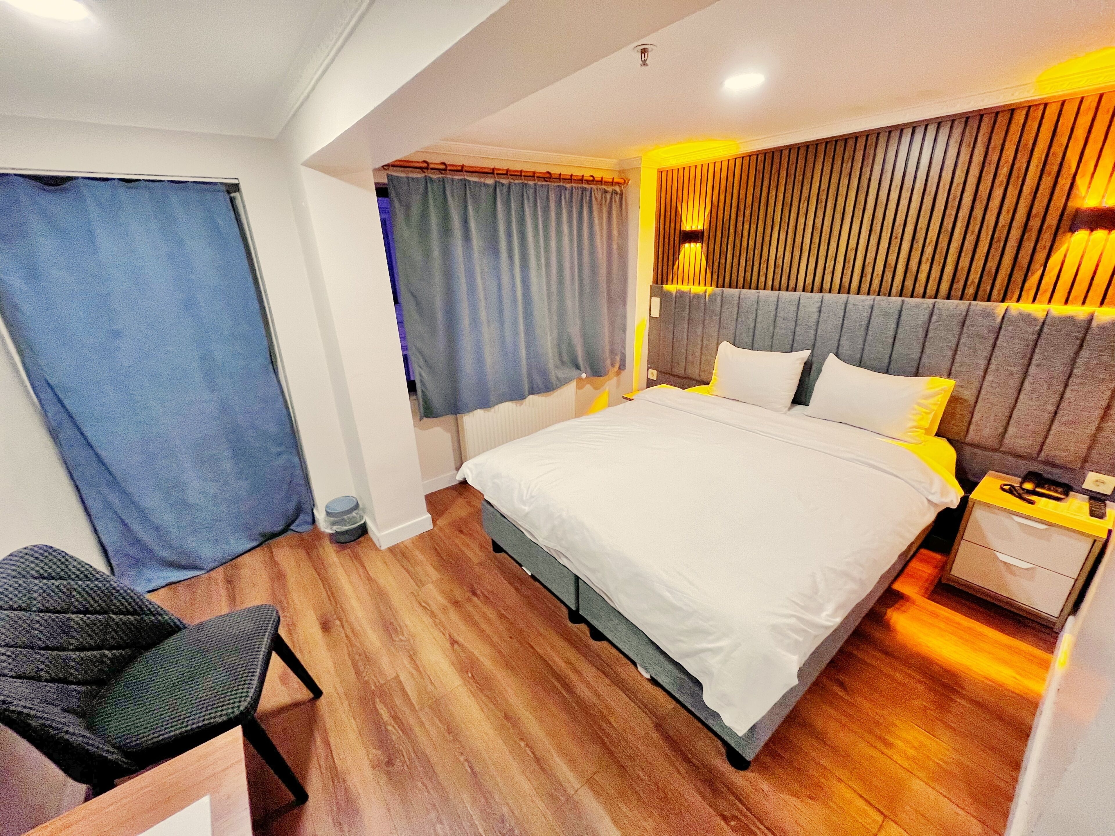 Ein modernes Hotelzimmer mit einem großen Bett, einem Schreibtisch und einem Sessel.