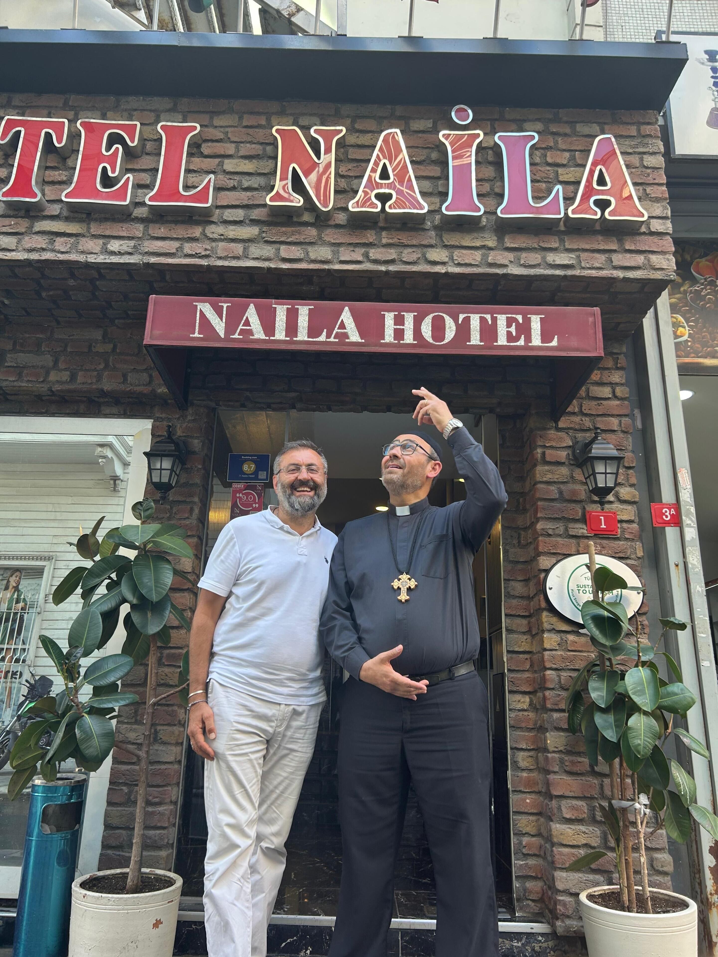 A hotel entrance with a sign reading 'NAILA HOTEL' and a brick facade.