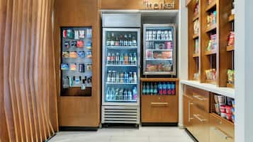 A store with shelves stocked with various products, a refrigerated section, and a section with packaged goods.