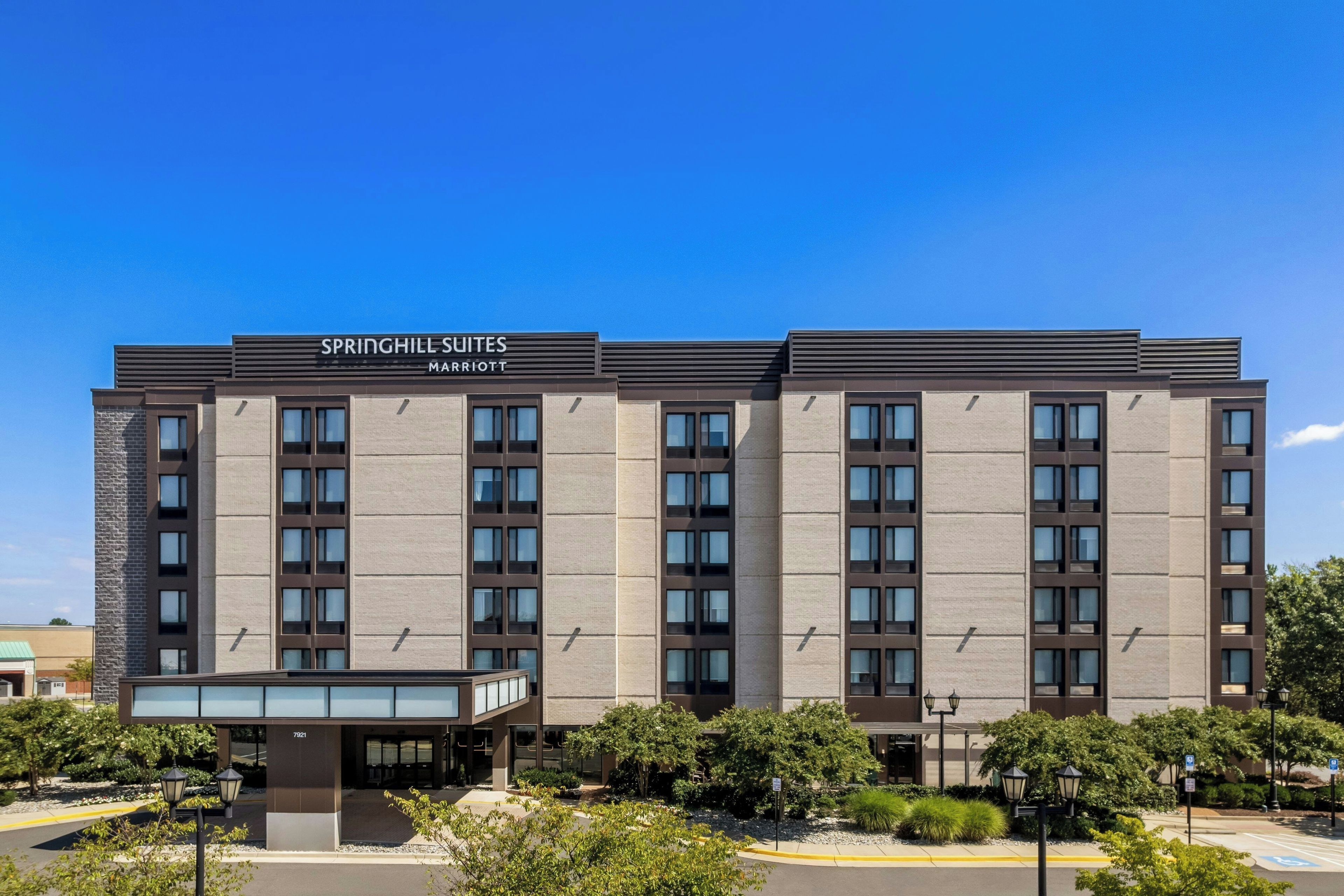 A multi-story hotel with a modern facade, featuring a prominent signage for 'SPRINGHILL SUITES MARRIOTT' at the top.