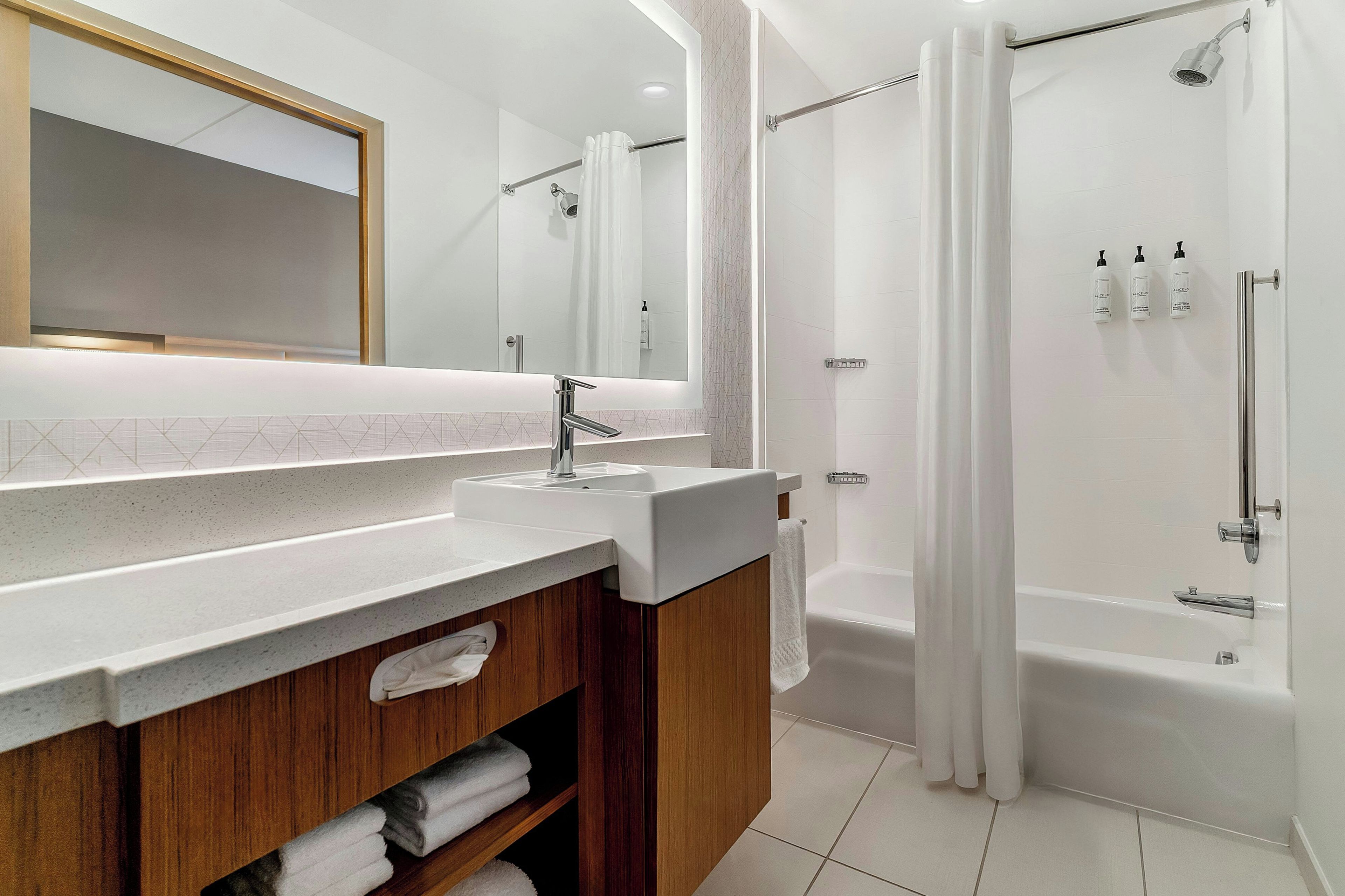 Un baño moderno con tocador, bañera y zona de ducha.
