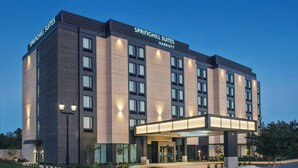 A modern hotel with a brick facade, large windows, and a well-lit entrance. - SpringHill Suites by Marriott Gainesville Haymarket (Gainesville)