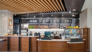 A modern bistro with a wooden counter, menu boards, and a variety of beverages and snacks. - Courtyard by Marriott Niagara Falls USA (Niagara Falls)