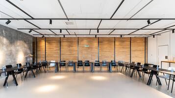 Un salón de conferencias con una larga mesa, varias sillas y un revestimiento de madera en la pared.