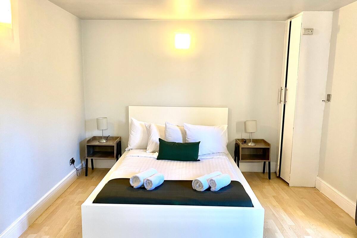 Ett modernt hotellrum med en stor säng, två sängbord och en garderob.